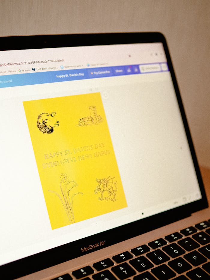creative-02 Close-up of a laptop showing a yellow St. David's Day greeting card design on the screen.