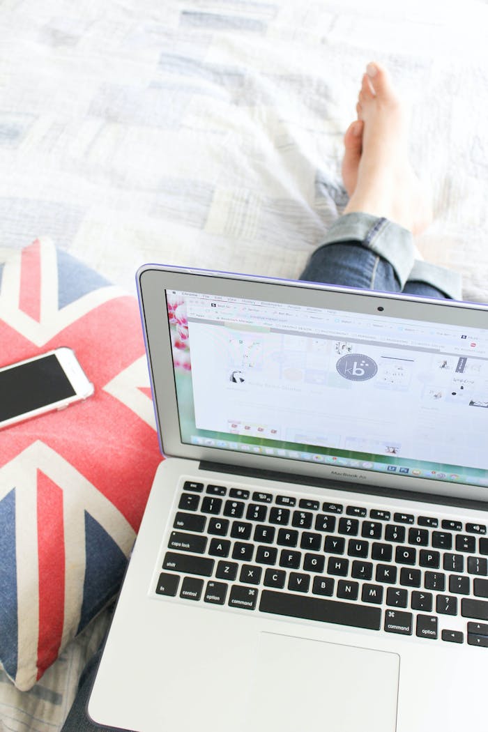 digital-01 Relaxing work setup on bed with laptop and smartphone, perfect for remote work.